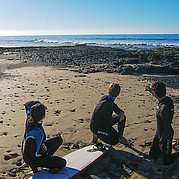 Surflessen op verlaten strand met schoon golven