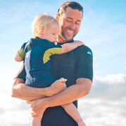Mama is aan het surfen, papa past op het kind, familiesurfcursus op Fuerteventura